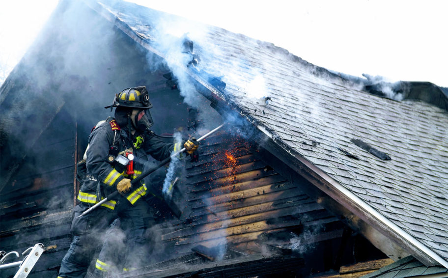 Fire fighter putting out roof on fire