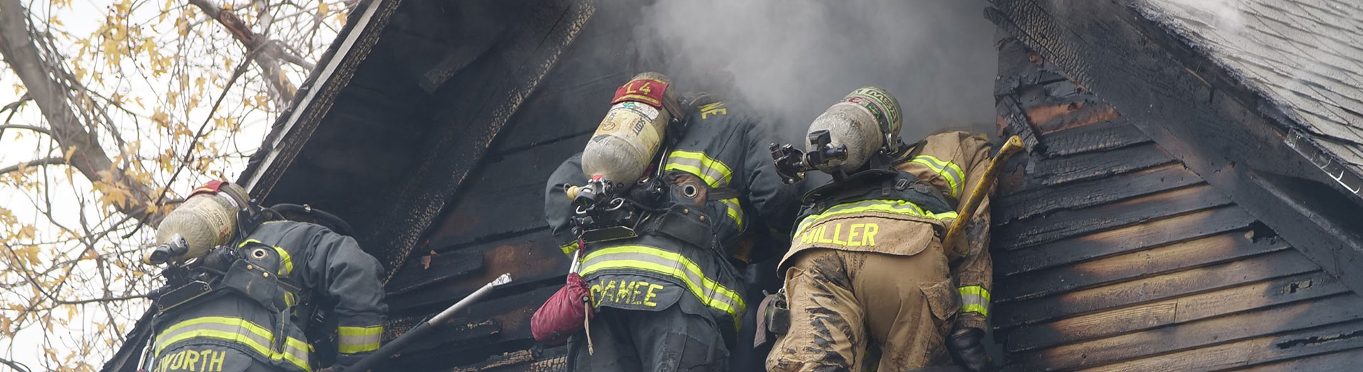 three fire fighters enter burning house through upper window